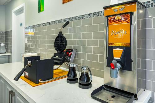 a kitchen counter with a coffee machine and a drink dispenser at Quality Inn & Suites in Grimsby