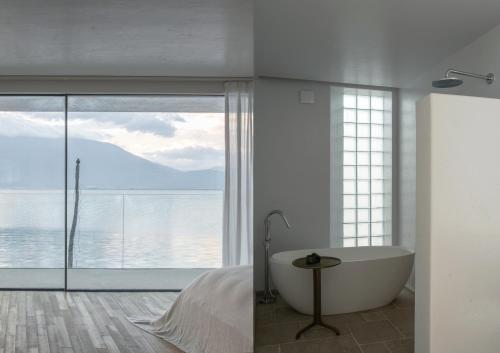 a bathroom with a tub and a view of the ocean at Dali Xishang Shuanglang Hotel in Dali Shuanglang