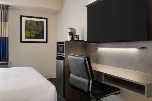 a room with a desk and a chair in a hotel room at Microtel Inn & Suites by Wyndham Boisbriand in Sainte-Thérèse-de-Blainville