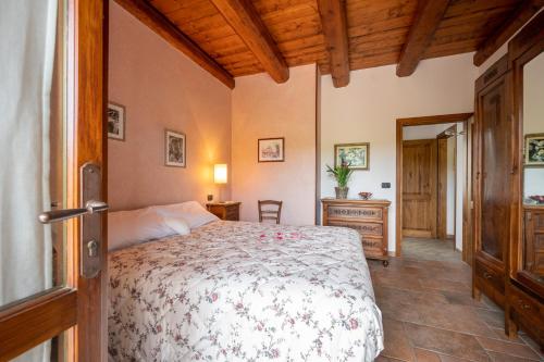 a bedroom with a bed and a wooden ceiling at Cascina Galarin in Castagnole Lanze