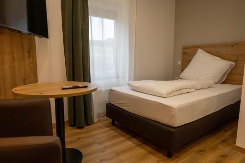 a small room with a bed and a table at HLN APARTMENTS Am Bahnhof in Saarbrücken