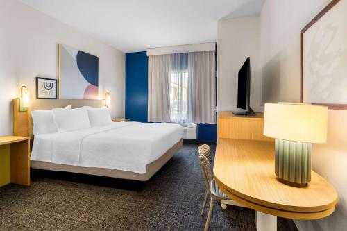 a hotel room with a large bed and a desk at Spark by Hilton Pearland in Pearland