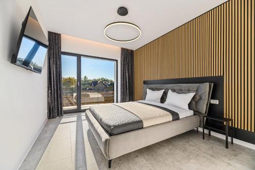 a bedroom with a bed and a large window at KOA - Nest in Braşov