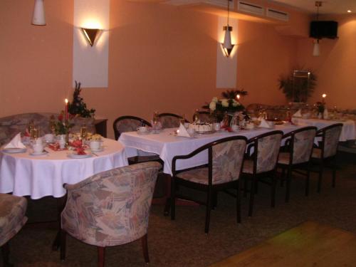 a dining room with white tables and chairs with candles at Hotel-Restaurant Marcus in Malchin