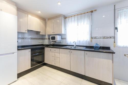 a kitchen with white cabinets and a sink at Azul in Daimuz