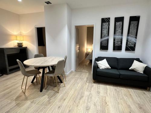 un salon avec un canapé noir et une table dans l'établissement Maison de l'Aar Appartement Le Rubis luxueux et cosy neuf, à Strasbourg