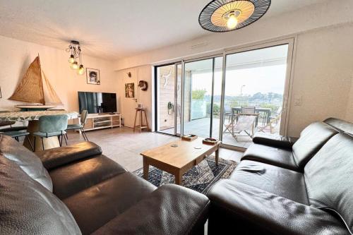 un salon avec un canapé et une table dans l'établissement T3 de standing - Vue océan 180, à Guidel