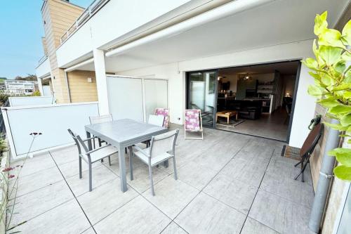 une table et des chaises sur le balcon d'une maison dans l'établissement T3 de standing - Vue océan 180, à Guidel