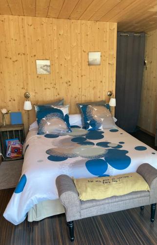 un grand lit avec des oreillers bleus dans une chambre dans l'établissement Chambre d'HÔTE Maison De L'amitié, à Lanton