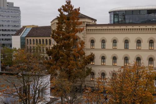 a tall building with a tree in front of it at HLN APARTMENTS Am Bahnhof in Saarbrücken
