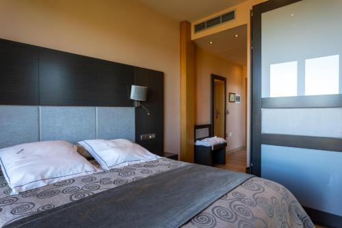 a bedroom with a large bed with white pillows at Hotel Felisa SPA in Queveda