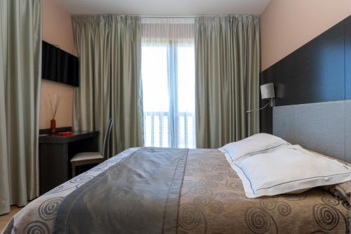 a bedroom with a bed and a desk and a window at Hotel Felisa SPA in Queveda