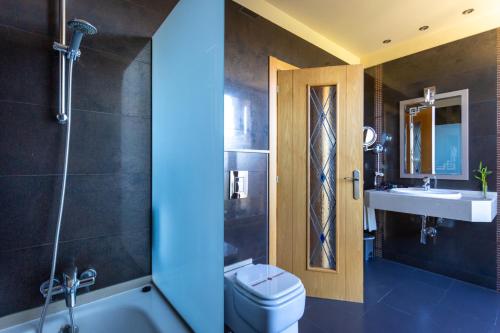 a bathroom with a toilet and a sink at Hotel Felisa SPA in Queveda