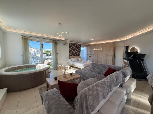 a living room with a large couch and a tub at Sunny Home Private Jacuzzi Hydromassage, Fireplace, Acropolis & Lycabettus View, Underground Parking, 300m Metro Peristeri in Athens