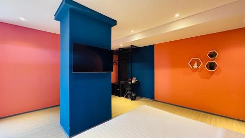 a room with colorful walls and a tv at Yellow Bee Resort Cililitan in Jakarta