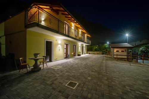 a building with a balcony and a patio at night at Il Girasole Bed and Breakfast in Donnas