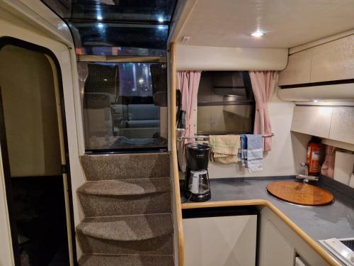 an rv kitchen with stairs and a counter top at Prinsessan i Lilla Bommen in Gothenburg