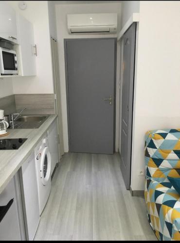 une petite cuisine avec un lave-linge et une porte dans l'établissement studio centre ville, à Ajaccio