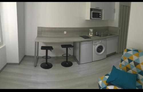 - une cuisine avec un comptoir et deux tabourets dans une pièce dans l'établissement studio centre ville, à Ajaccio