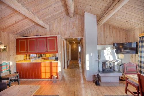 a kitchen with red cabinets in a wooden house at Nostalgic Cabin with 3 BR, Fireplace, and Terrace in Beitostøl