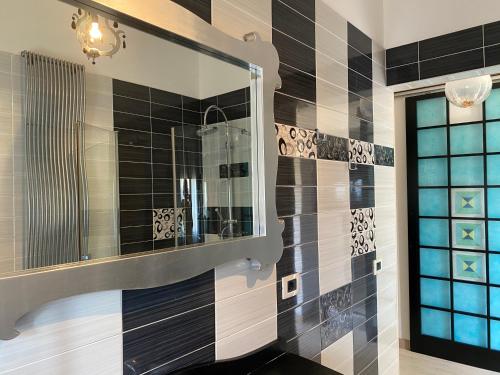 a bathroom with a mirror and black and white tiles at Appartamento Casa Anna in Garda