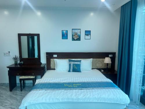 a bedroom with a large bed and a mirror at View Point - Anh Quan in Cat Ba