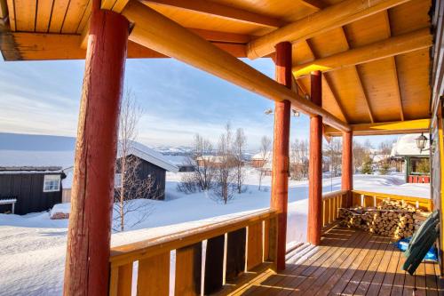 a wooden porch with snow on the ground at Nostalgic Cabin with 3 BR, Fireplace, and Terrace in Beitostøl