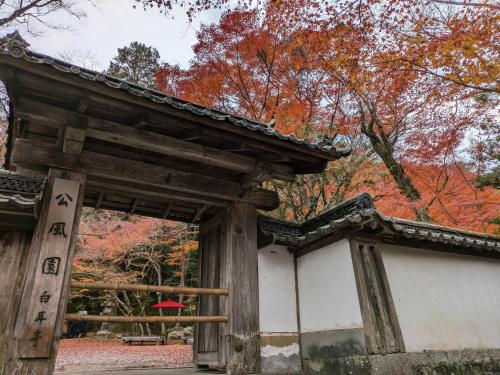 an entrance to a shrine with autumn leaves at Villa Ishiyamadera ヴィラ 石山寺 in Otsu