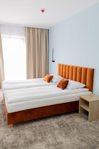a large bed in a room with a large window at Plaża Resort Łeba & Wellness in Łeba