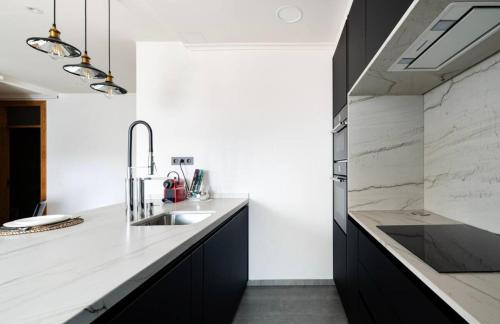 a kitchen with a sink and a counter at Apartamento céntrico y moderno con vistas a la Ría in Vigo