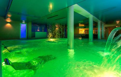 a swimming pool with a fountain in a building at Hotel Felisa SPA in Queveda