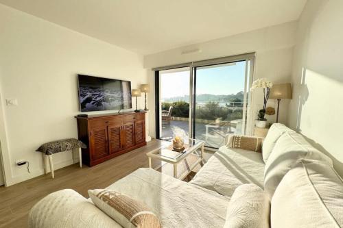 un salon avec un canapé et une grande fenêtre dans l'établissement Luxury T2 de standing - Vue mer 180, à Guidel