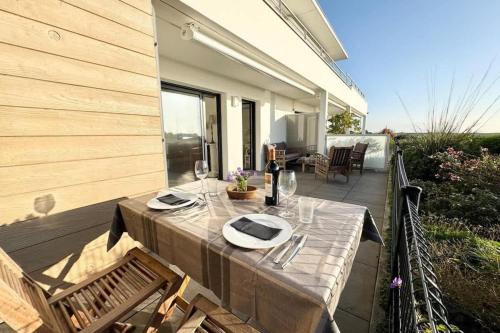 une table avec des verres et des assiettes sur une terrasse dans l'établissement Luxury T2 de standing - Vue mer 180, à Guidel