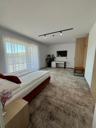 a large bedroom with a large bed and a flat screen tv at Plaża Resort Łeba & Wellness in Łeba