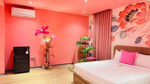 a bedroom with a bed and a red wall at Yellow Bee Resort Cililitan in Jakarta
