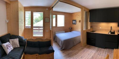 une chambre avec un lit et un canapé dans une pièce dans l'établissement Pretty T2 with balcony and view to the slopes, à Saint-Chaffrey