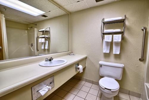 ein Badezimmer mit einem Waschbecken, einem WC und einem Spiegel in der Unterkunft Katahdin Inn & Suites in Millinocket