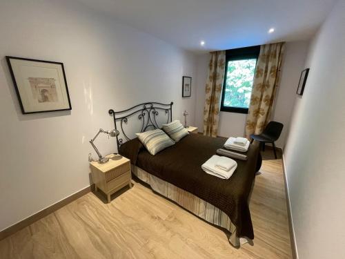 a bedroom with a bed and a chair and a window at La avellaneda in Arenas de San Pedro