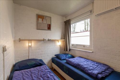 ein Zimmer mit zwei Betten und einem Fenster in der Unterkunft Bungalowpark Simpelveld - Schakel 24 in Simpelveld