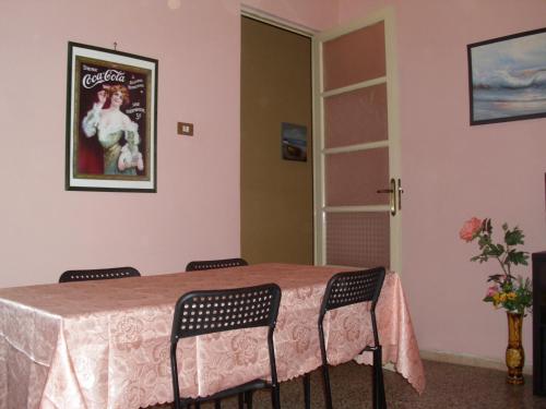 une table à manger avec des chaises et une photo sur le mur dans l'établissement B&B Bella Stella, à Catane