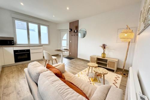 un salon avec un canapé et une table dans l'établissement Lovely ! T2 neuf archi cosy 1, à Quimperlé