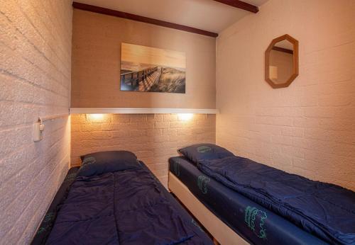a bedroom with two beds and a wall at Bungalowpark Simpelveld - Schakel 16 in Simpelveld