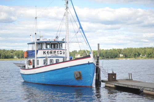 a blue boat is docked at a dock at Hotel Sea Front in Tammisaari