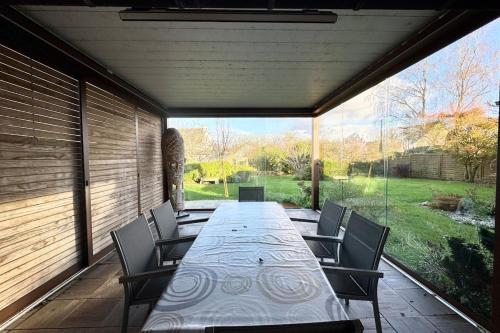 a long table and chairs on a patio at Spacieuse longère archi cosy - Jardin in Quimperlé