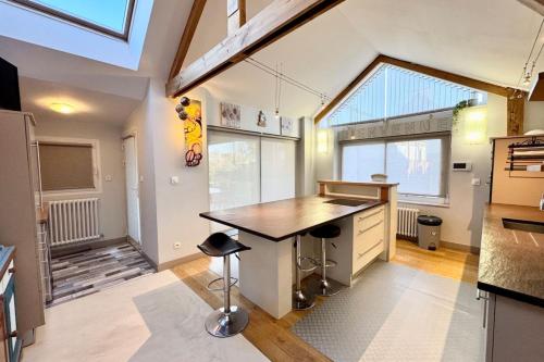 une cuisine avec un comptoir et une grande fenêtre dans l'établissement Spacieuse longère archi cosy - Jardin, à Quimperlé