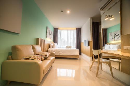 a living room with a couch and a bed at The Bliss Ubon in Ubon Ratchathani