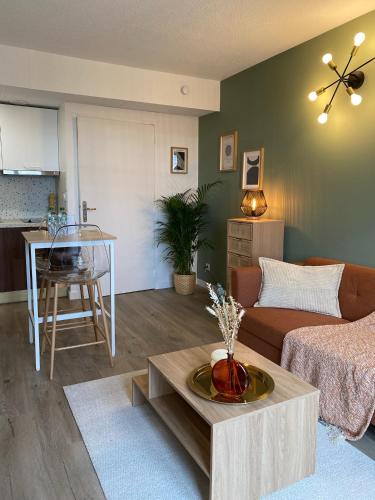 un salon avec un canapé et une table dans l'établissement L'Écrin de Jaude - Duplex by PRIM0 C0NCIERGERIE, à Clermont-Ferrand