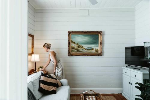 a woman standing on a bed in a room at Benambra Cottage c1860 in Queenscliff