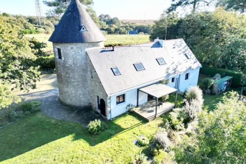 - une vue aérienne sur une maison blanche avec une tour dans l'établissement Longère de charme en pleine nature 3km des plages, à Guidel