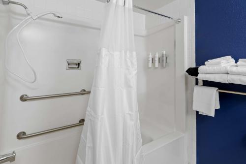 a shower with a white shower curtain in a bathroom at Spark by Hilton Daleville Roanoke North in Daleville